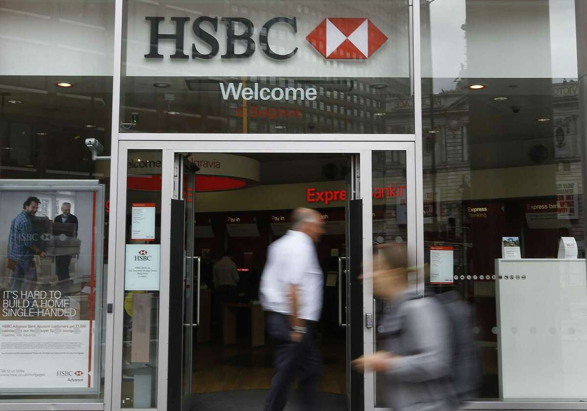 Pedestrians pass a branch of HSBC in London on June 9, 2015. HSBC Holdings, Britain’s largest bank by market value, will cut between 22,000 and 25,000 jobs around the world in an attempt to reduce costs and shift its center of gravity back towards fast-growing Asian economies.