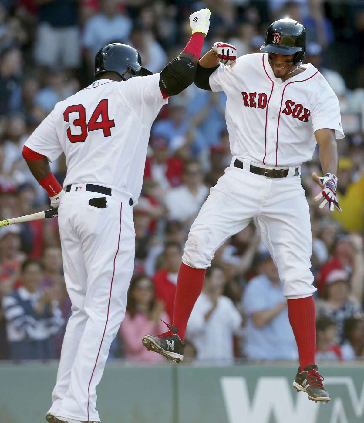 Xander Bogaerts, right, leaps to celebrate with David Ortiz after hitting a home run during the fifth inning on Saturday.