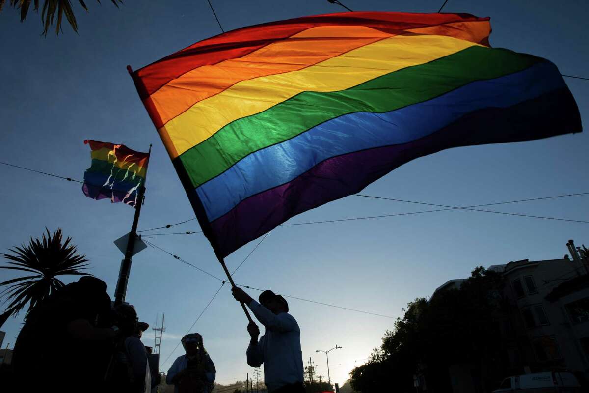 Tre Allen waves the rainbow flag in the Castro during a memorial for Gilbert Baker on Friday, March 31, 2017, in San Francisco, Calif. The memorial was for Baker, who designed the rainbow flag. Friends said Baker, age 65, died Thursday in his sleep at his home in New York. The rainbow flag has since become a symbol of the LGBT community recognized worldwide Ã©?‘ celebrated at pride festivals, brandished at protests and raised every morning at the corner of Castro and Market streets.