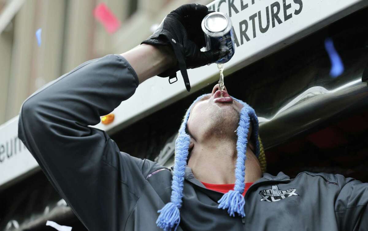 New England Patriots tight end Rob Gronkowski chugs a beer, tossed to him by a fan, during Wednesday’s parade in Boston.