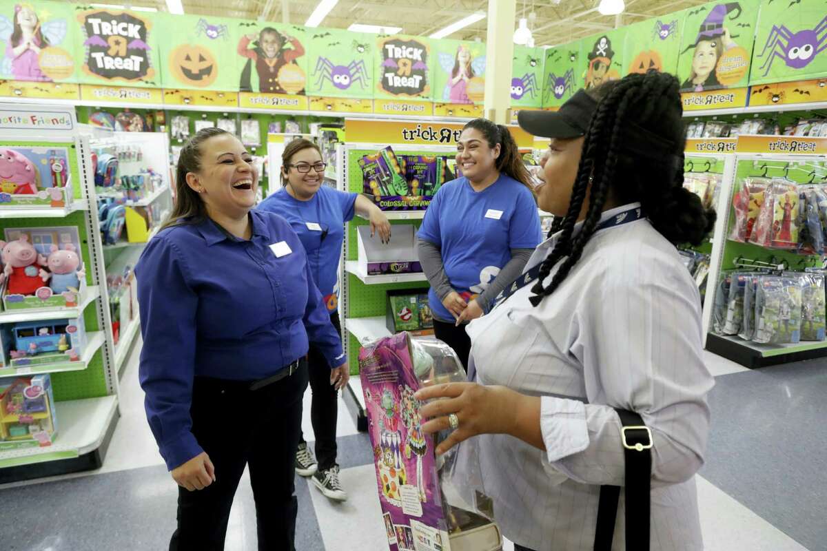 Store manager Christina Whitt, left, jokes with customer Kelly Stenhouse, right, at a Toys R Us store in San Jose. Whitt and workers Mitzi Solorio, background left, and Crystal Gomez, background right, all are former seasonal employees now working full time for the chain. Retailers are dangling lots of incentives to lure temporary holiday workers in a tight labor market. That includes increased pay, additional discounts and more flexibility in schedules.