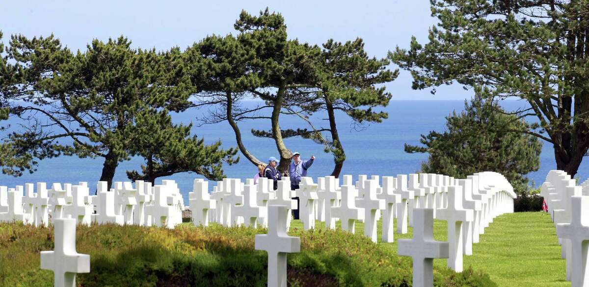 Visitors walk among graves at the Colleville American military cemetery, in Colleville sur Mer, western France, Saturday June 6, 2015, on the 71th anniversary of the D-Day landing. D-Day marked the start of a Europe invasion, as many thousands of Allied troops began landing on the beaches of Normandy in northern France in 1944 at the start of a major offensive against the Nazi German forces, an offensive which cost the lives of many thousands. (AP Photo/Remy de la Mauviniere)