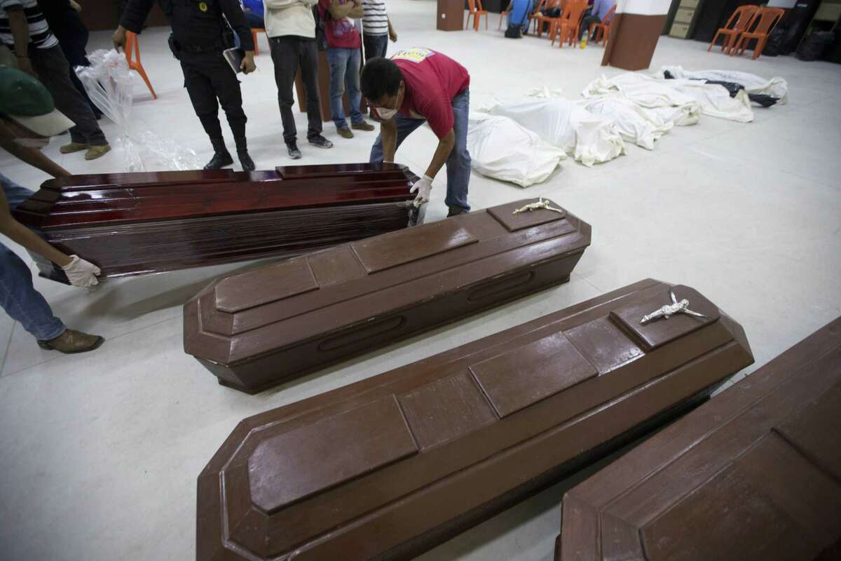 Volunteers arrange coffins at a provisional morgue in Santa Catarina Pinula, Guatemala, Friday, Oct. 2, 2015. The hill that towers over the Santa Catarina Pinula neighborhood known as Cambray, collapsed late Thursday after heavy rains, burying several houses with dirt, mud and rocks. Family members have reported 100 people missing, but the number could be as high as 600 based on at least 100 homes in the area of the slide, said Alejandro Maldonado, executive secretary of Conred, the country’s emergency disaster agency.