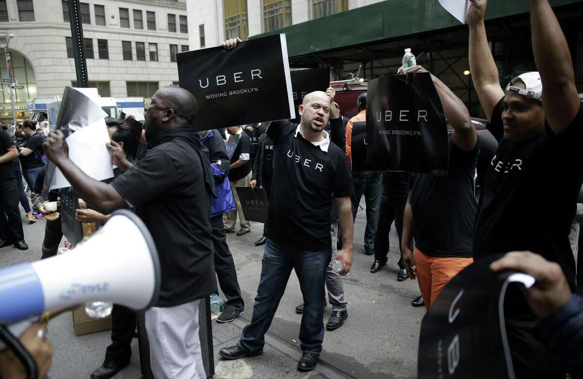 Uber drivers and their supporters protest in front of the offices of the Taxi and Limousine Commission in New York.