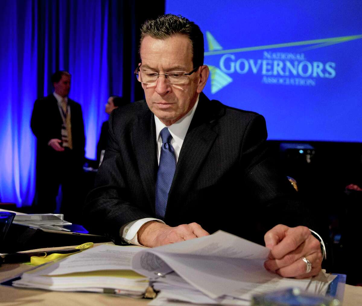 Connecticut Gov. Dannel P. Malloy reads documents during the National Governors Association 2013 Winter Meeting in Washington on Feb. 23, 2013.