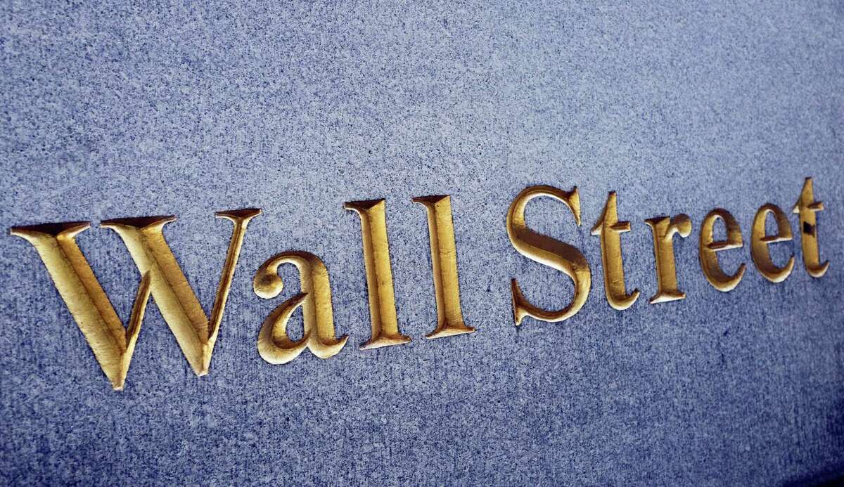 A sign for Wall Street is carved into a building located near the New York Stock Exchange.