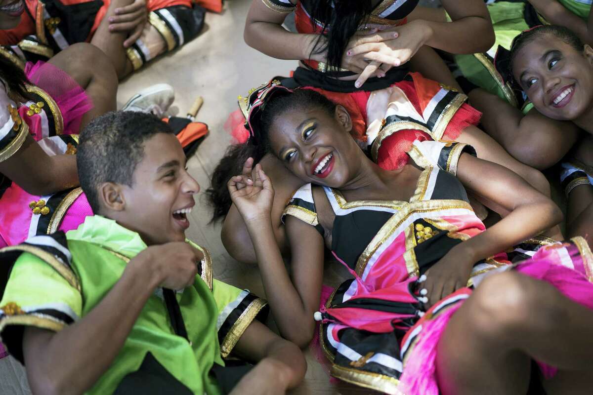 Young revelers joke with each other as they lay on the shade during the “Burial of the Mosquito” carnival block parade in Olinda, Pernambuco state, Brazil, Friday, Feb. 5, 2016. The parade that happens every year during carnival inform residents and tourists about the dangers of the Aedes aegypti and teaches them how to combat the mosquito.