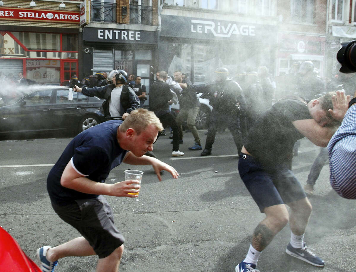 English fans run after getting sprayed with pepper spray by French police during scuffles in downtown Lille, northern France, Wednesday, June 15, 2016, one day ahead of the Euro 2016 Group B soccer match against Wales in nearby Lens. Russia were playing Slovakia at the Pierre Mauroy stadium in Villeneuve d’Ascq, near Lille on Wednesday which raised the possibility of violence after clashes between supporters from the two countries at their previous match in Marseille last weekend.