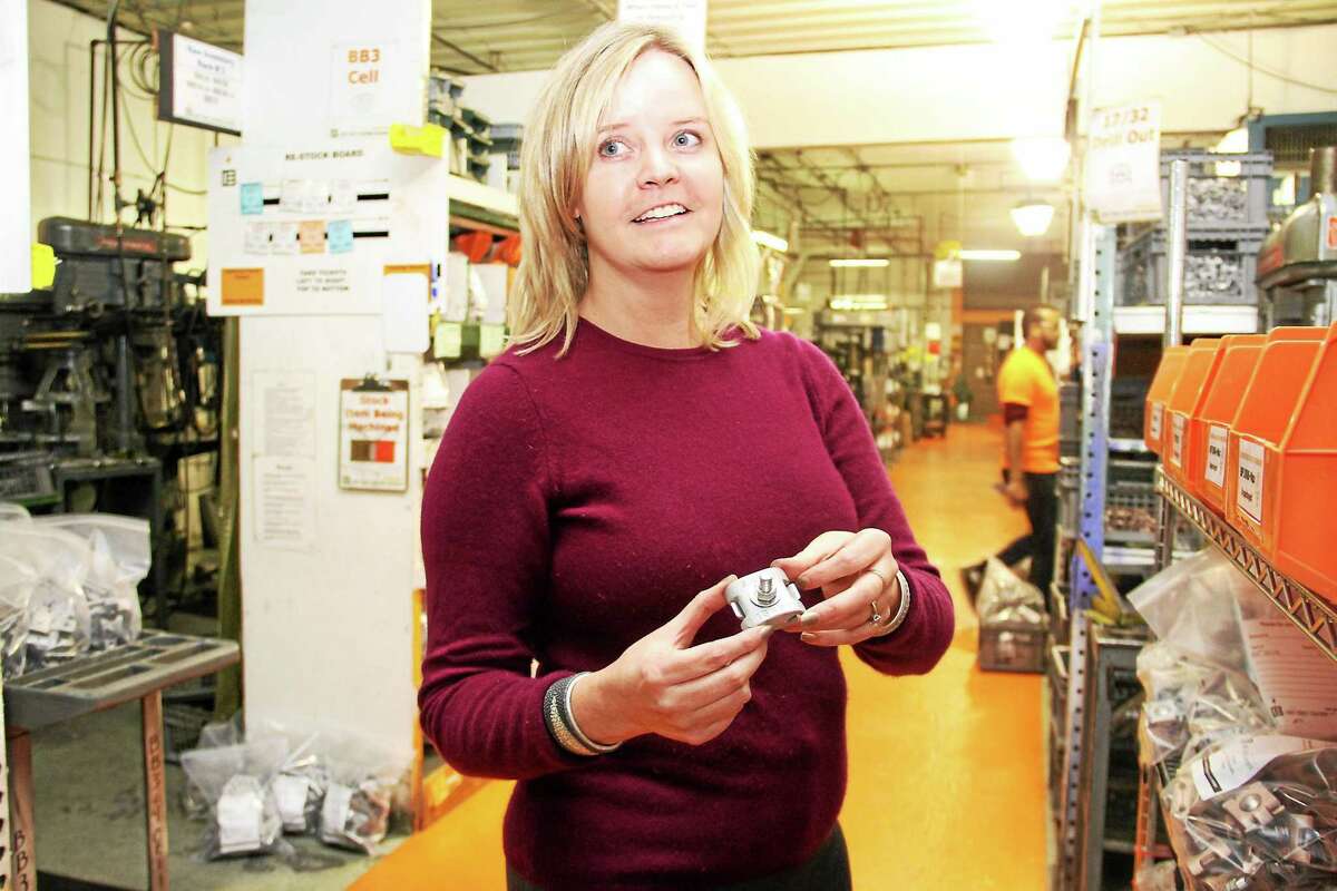 Jennifer Morgan, co-owner of East Coast Lightning Equipment in Winsted, holds a clamp manufactured on site at the facility that makes and sells lightning protection systems for commercial buildings, schools, health care facilities and homes.