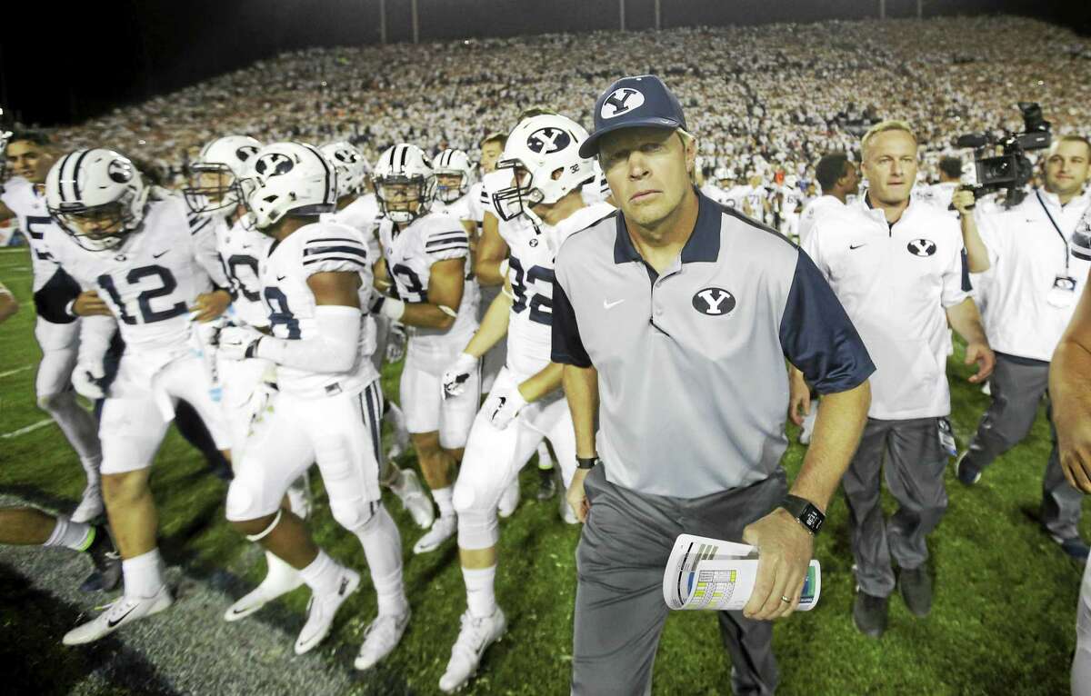 BYU head coach Bronco Mendenhall leads his team on the field earlier this season in Provo, Utah. BYU will host UConn on Friday night.
