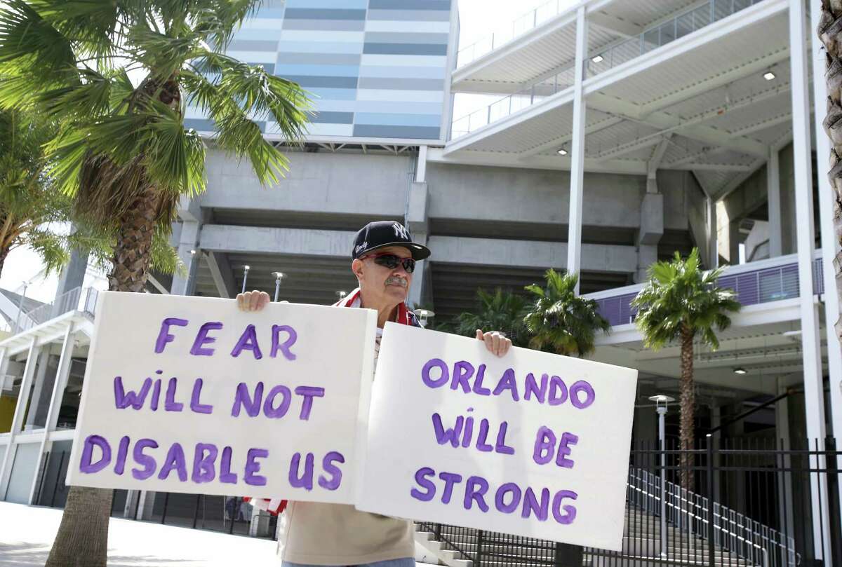 Andy Garcia, walks around Camping World Stadium, holding signs in support of the victims of the recent mass shootings and their families at the Pulse nightclub on June 15, 2016, in Orlando, Fla. The stadium opened an assistance center for victims and their families today.