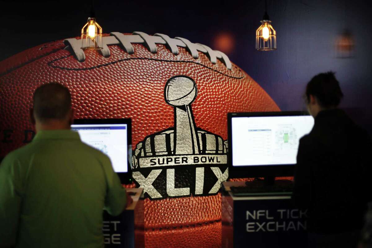 A mural of a football decorates the wall of an Super Bowl XLIX ticket office as customers check for seating availability on Saturday in Phoenix.