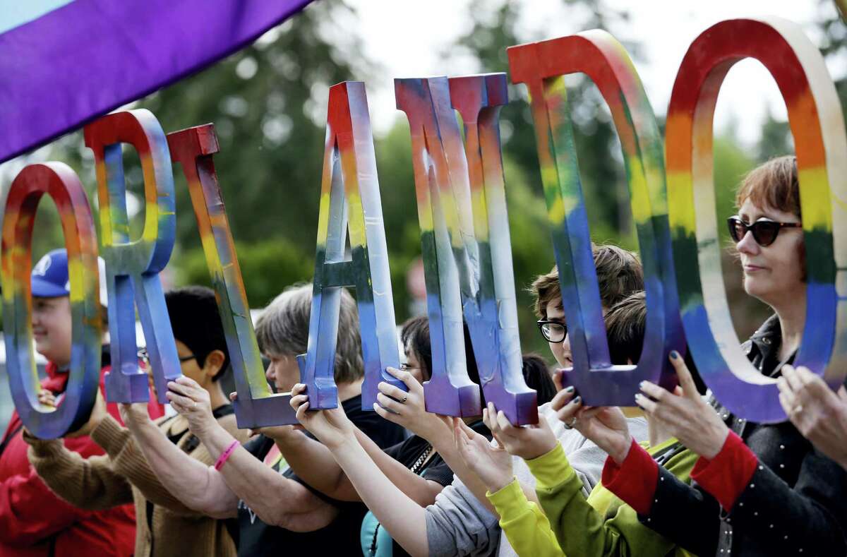 Members of Capital City Pride and others from the LGBT community hold up letters spelling out “Orlando” to honor of the recent shooting at a gay nightclub days earlier before the raising of a rainbow flag in front of the Washington state Capitol Wednesday, June 15, 2016, in Olympia, Wash. The rainbow flag was raised to mark the start of Gay Pride month, and was immediately lowered to half-staff to mark last weekend’s mass shooting at a central Florida nightclub.