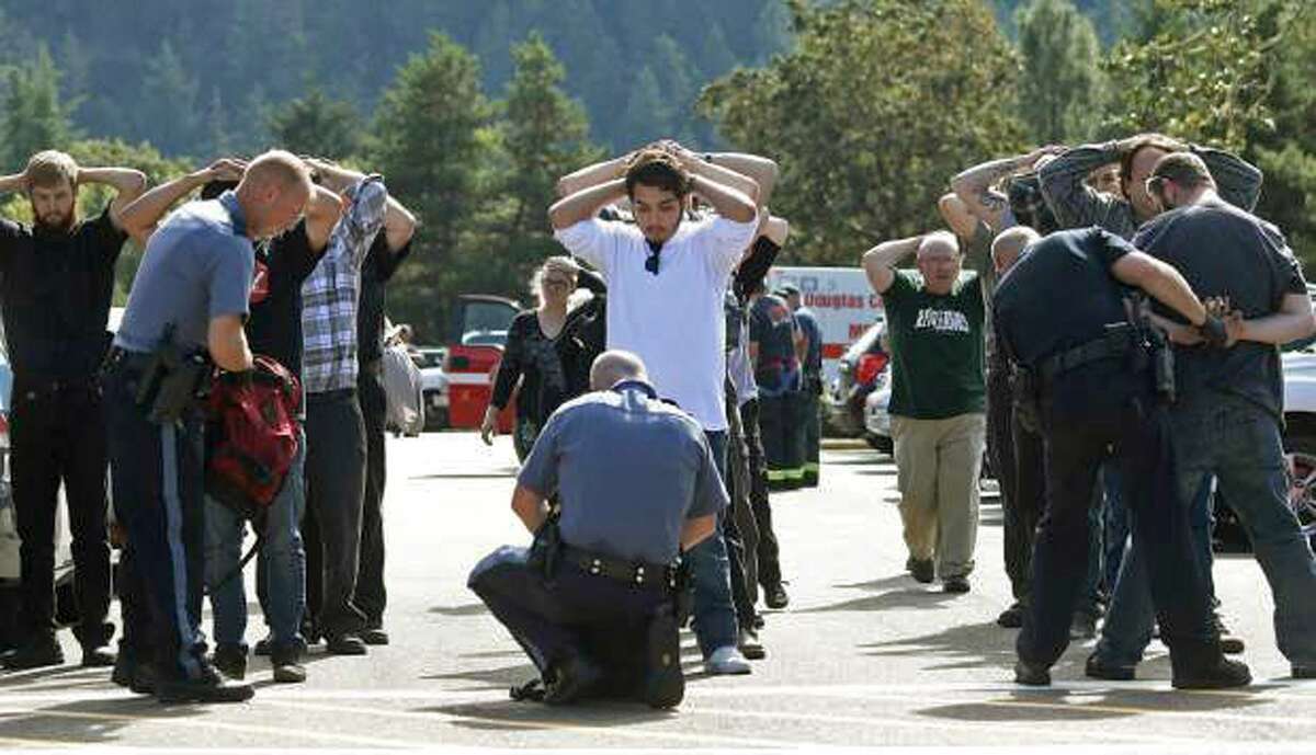 Police search students outside Umpqua Community College in Roseburg, Ore., Thursday, Oct. 1, 2015, following a deadly shooting at the college.