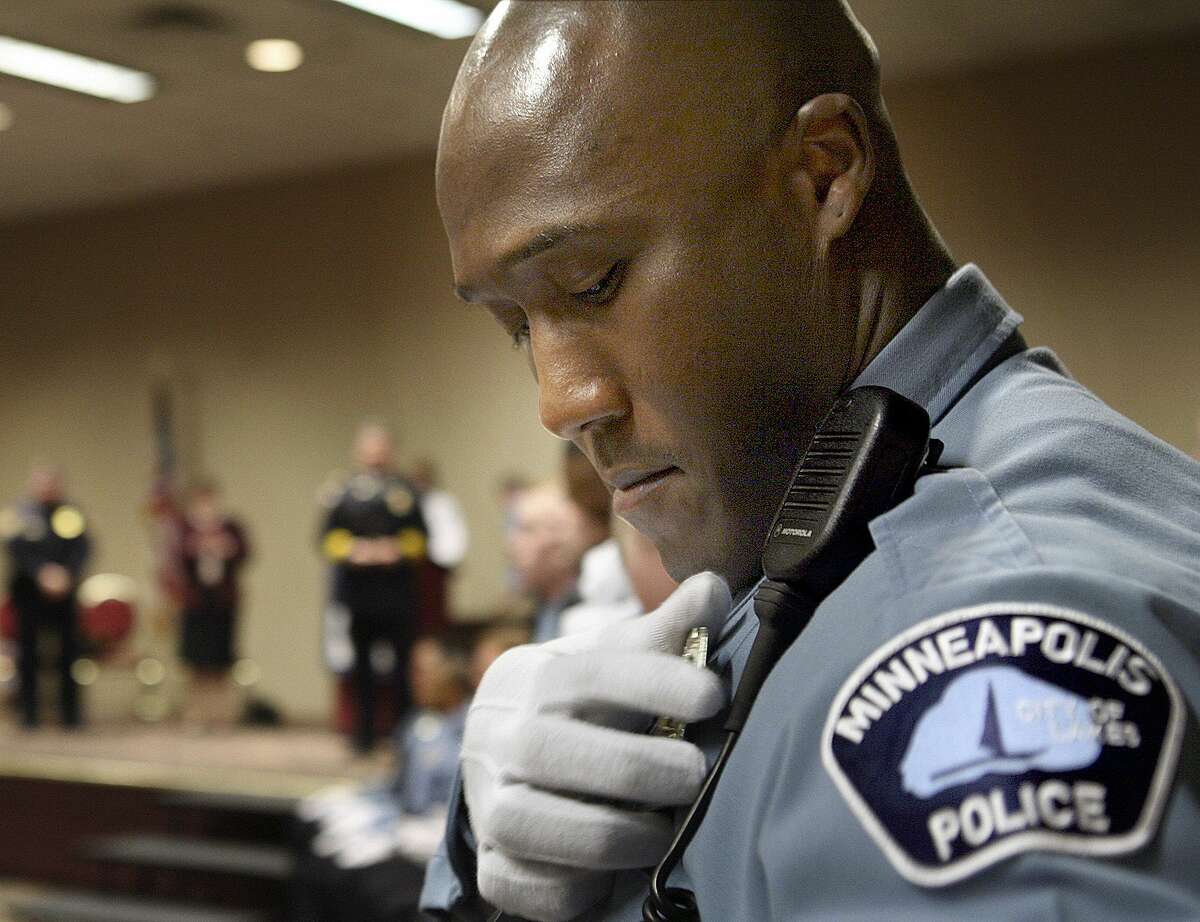 In this March 15, 2007, photo, Minneapolis Police Department Academy graduate Michael Griffin pins his badge onto his uniform during a graduation ceremony in Minneapolis. An indictment May 20 accuses Griffin of assaulting several people while off-duty and filing false reports.
