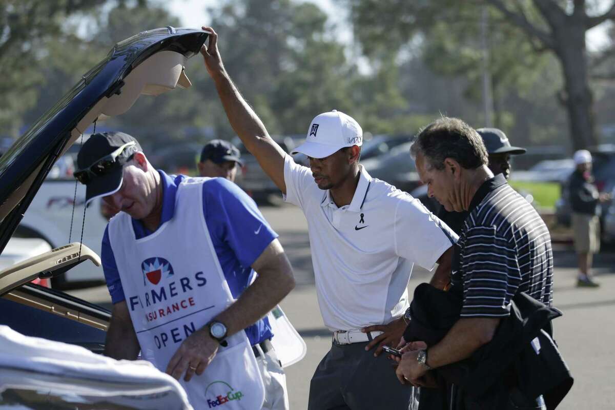 In this Feb. 5 file photo, Tiger Woods loads his car after withdrawing during the first round of the Farmers Insurance Open in San Diego.