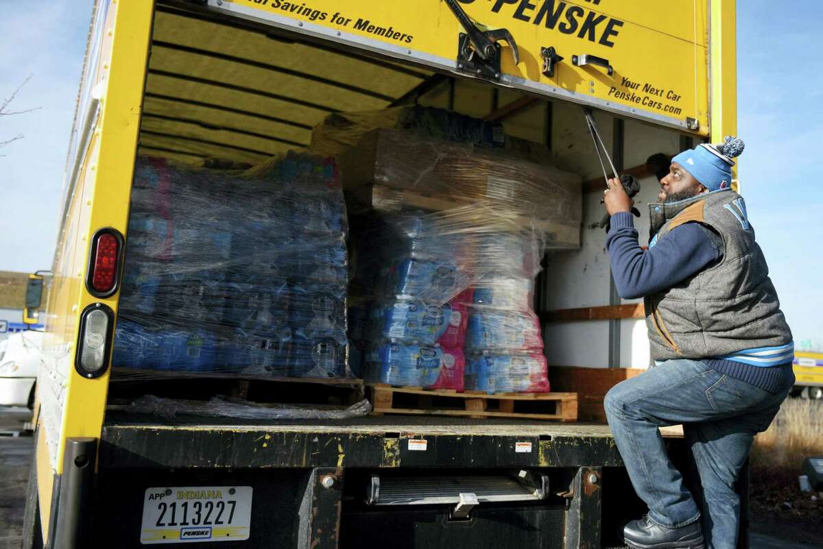Dwayne Maton, of Detroit, closes a truck’s door that is filled with water for Flint, Mich. on Feb. 1, 2016. Metro Detroit and Flint churches are working together to deliver cases of water after river water was not treated properly and lead from pipes leached into Flint homes.