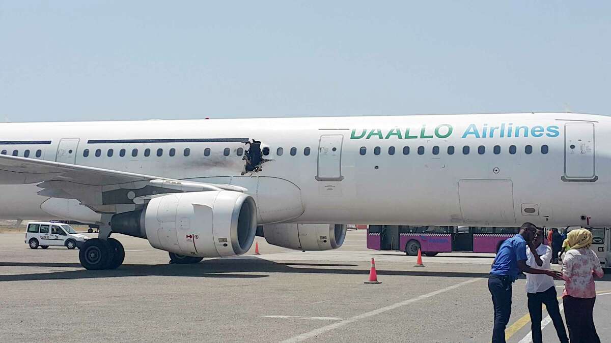In this photo taken Tuesday, Feb. 2, 2016, a hole is seen in a plane operated by Daallo Airlines as it sits on the runway of the airport in Mogadishu, Somalia. A gaping hole in the commercial airliner forced it to make an emergency landing at Mogadishu’s international airport late Tuesday officials and witnesses said.