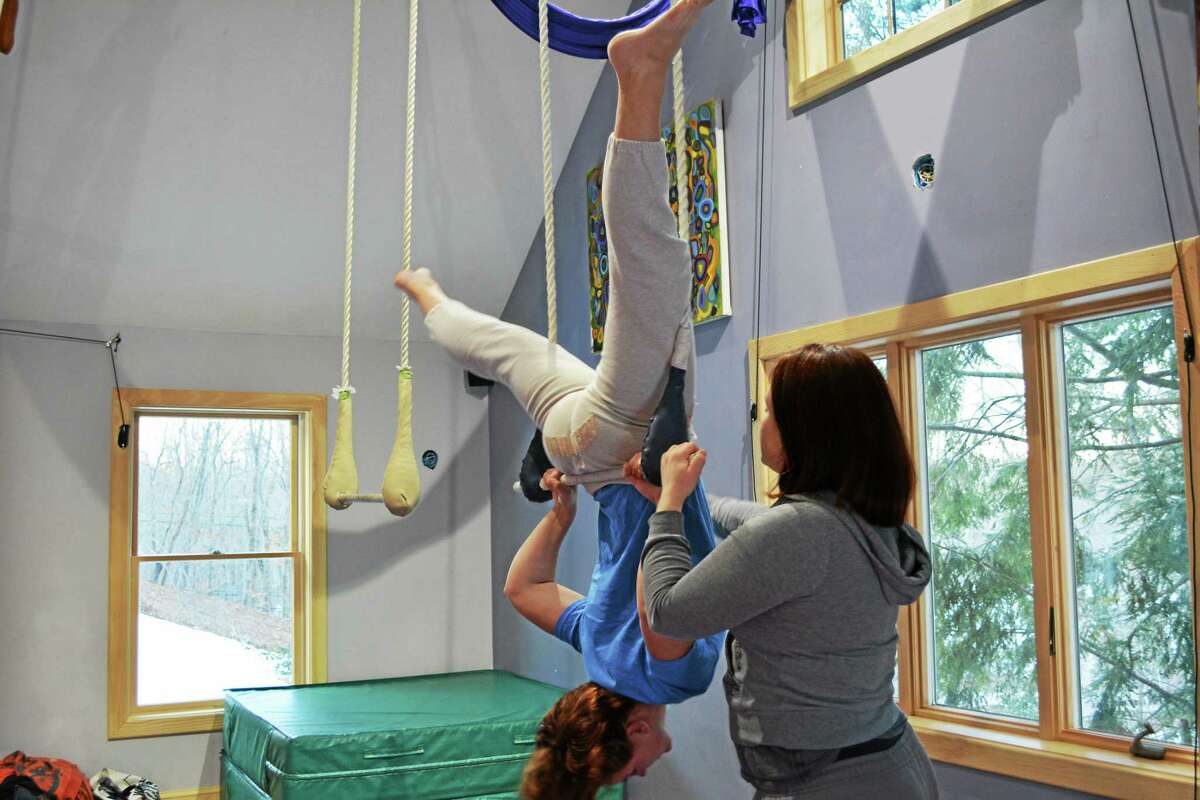 Student Jessica Crowell practices her aerial bar movements with help of instructor Jamie Hodgson.