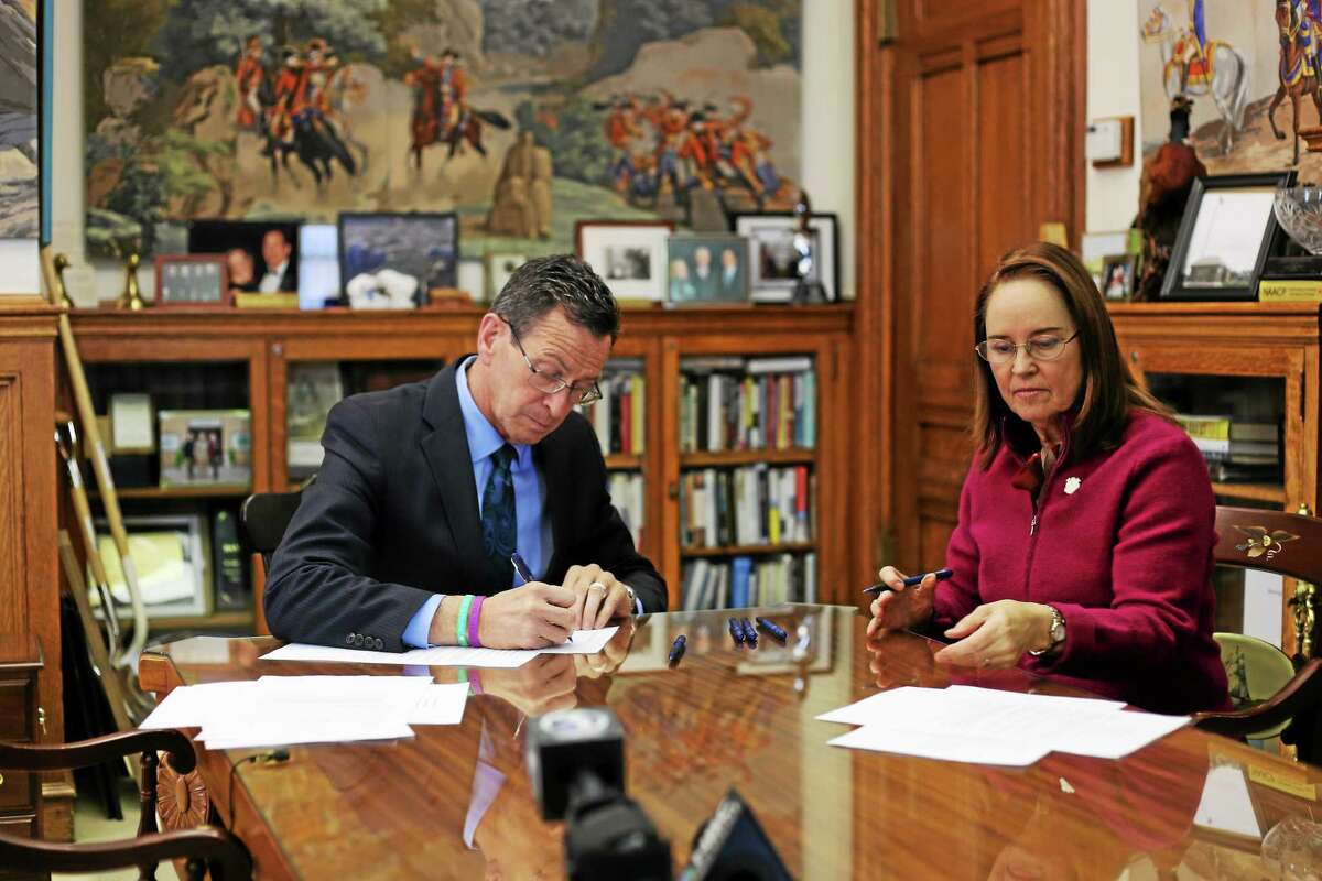 Gov. Dannel P. Malloy signs the executive order that bans state-funded travel to Indiana over its passage of the Religious Freedom Restoration Act and Secretary of the State Denise Merrill gets ready to make it official
