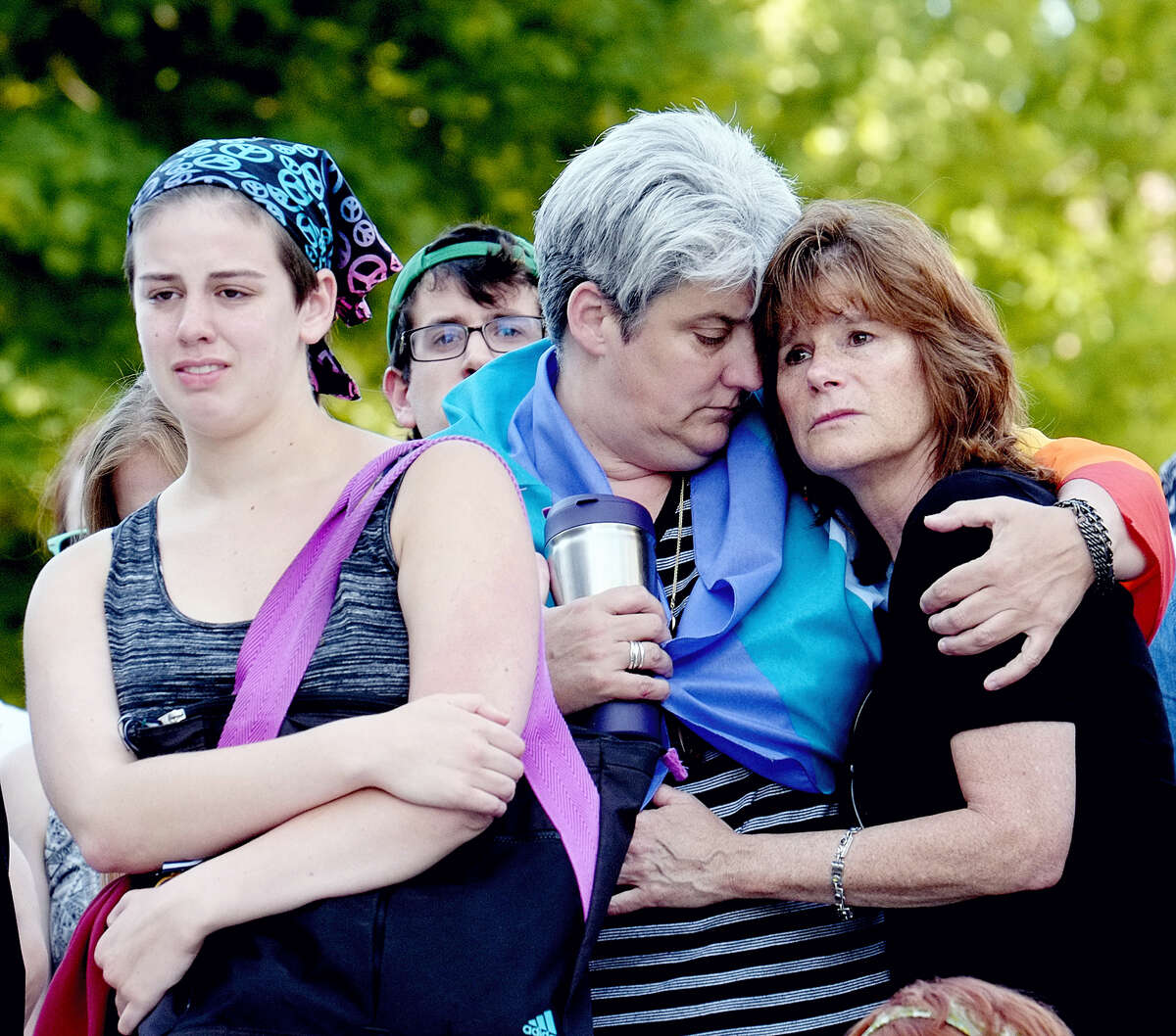 Aidan Wood, left, her mother, Lisa Laughman and Karen Pace console each other at a vigil for the mass shootings in Orlando, Fla., in Lansing, Mich. on June 12, 2016.