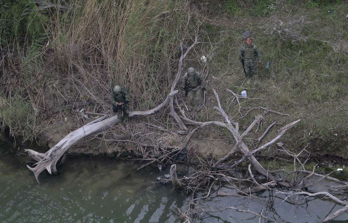 In this Feb. 24, 2015 photo, Mexican officials examine a body, lower center in the water, discovered by the U.S. Customs and Border Protection Air and Marine while on patrol near the Texas-Mexico border, in Rio Grande City, Texas.