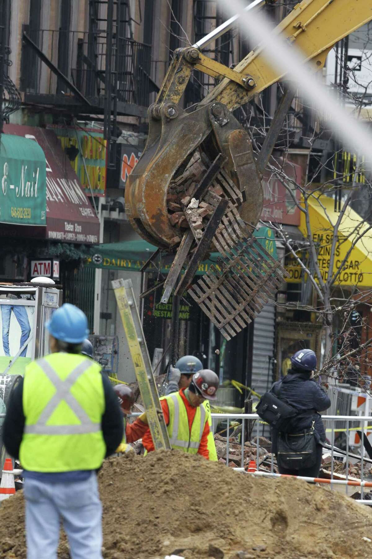 Debris are cleaned up from the site of a building collapse in the East Village neighborhood of New York on March 27, 2015. Nineteen people were injured, four critically, after the powerful blast and fire sent flames soaring and debris flying Thursday afternoon.