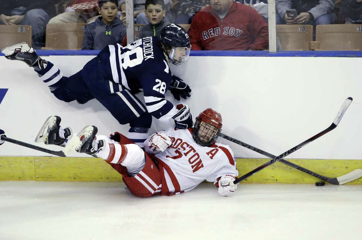 Yale’s Ryan Hitchcock and Boston University’s Cason Hohmann battle along the boards during the Terriers’ 3-2 overtime win in Friday’s NCAA tournament regional semifinal game in Manchester, N.H.