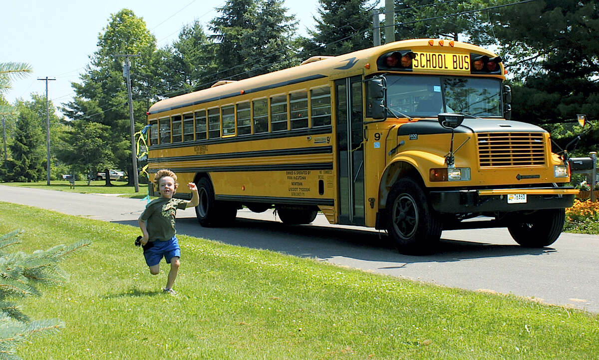 In this 2011 photo provided by Mark Barden, his son Daniel Barden runs alongside a school bus in Newtown, Conn. Daniel was among those killed during the Sandy Hook Elementary School shootings on Dec. 14, 2012 in Newtown. Mark Barden is one of the subjects in the documentary “Newtown,” which debuted earlier this year at the Sundance Film Festival.