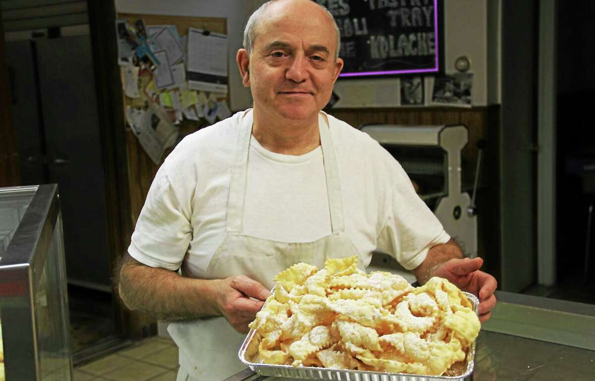 Camillo Lombardi holds a tray of angel wings at Lombardi’s Bakery in Torrington.