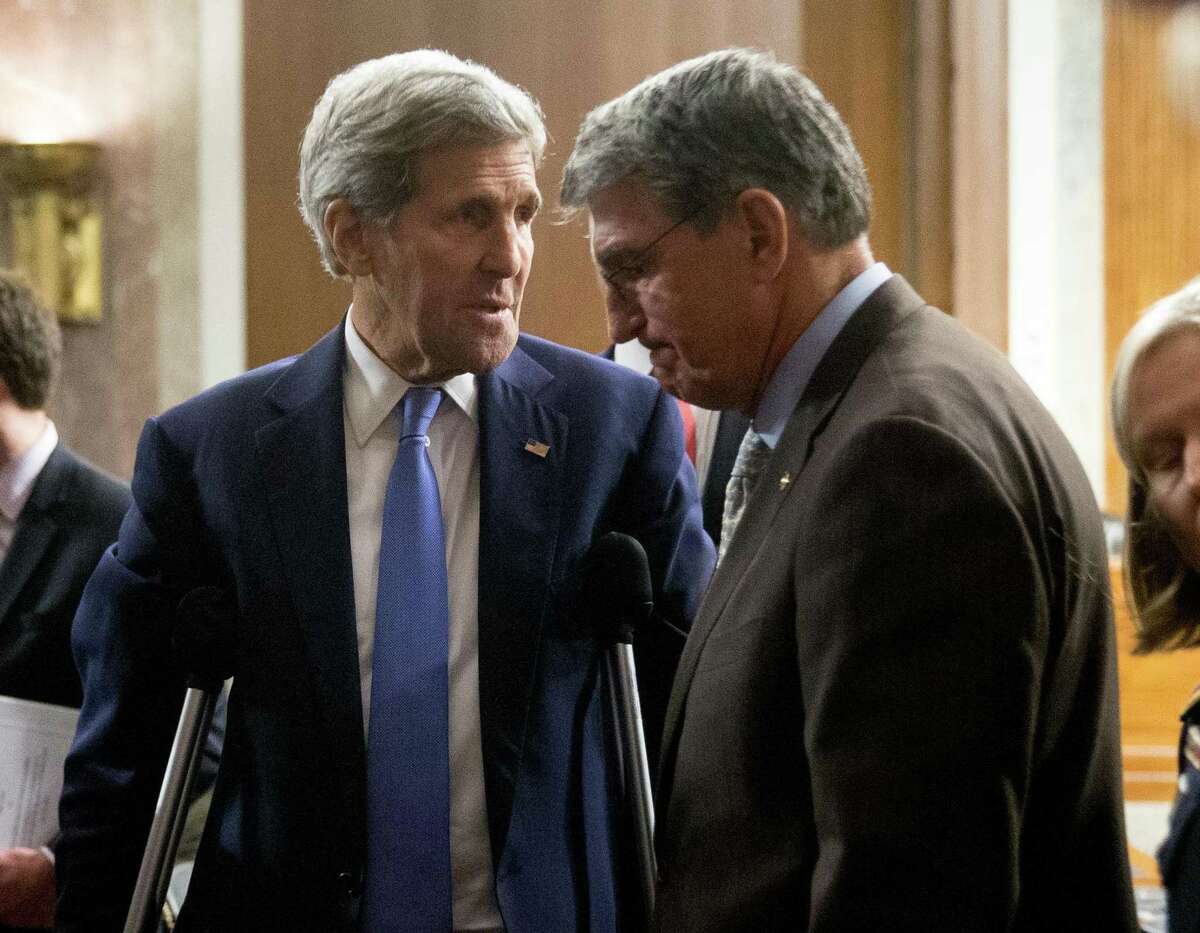 Secretary of State John Kerry talks with Senate Armed Services Committee member Sen. Joe Manchin, D-W.Va., on Capitol Hill in Washington on Wednesday.