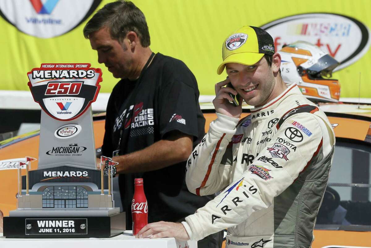 Daniel Suarez takes a phone call after winning the NASCAR Xfinity series race at Michigan International Speedway on Saturday.