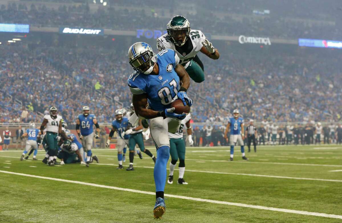 Detroit Lions receiver Calvin Johnson, defended by Philadelphia Eagles cornerback Eric Rowe, scores one of his three touchdowns on Thursday.
