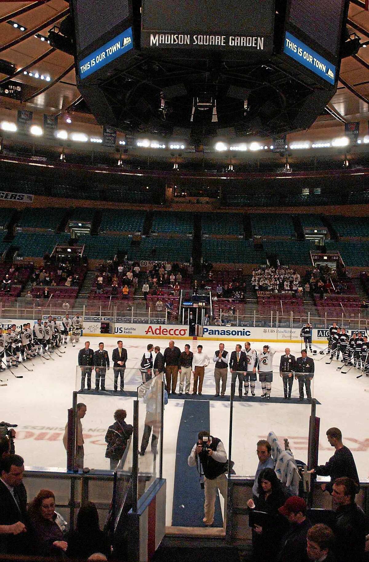 Members of the Quinnipiac and UConn hockey teams and administrators line up with representatives of firefighters and policemen during postgame ceremonies of the “Heroes Hat” at Madison Square Garden in 2003.