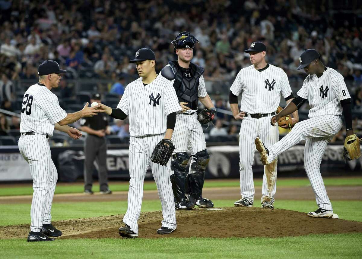 Yankees manager Joe Girardi takes the ball from starting pitcher Masahiro Tanaka during Saturday’s game.