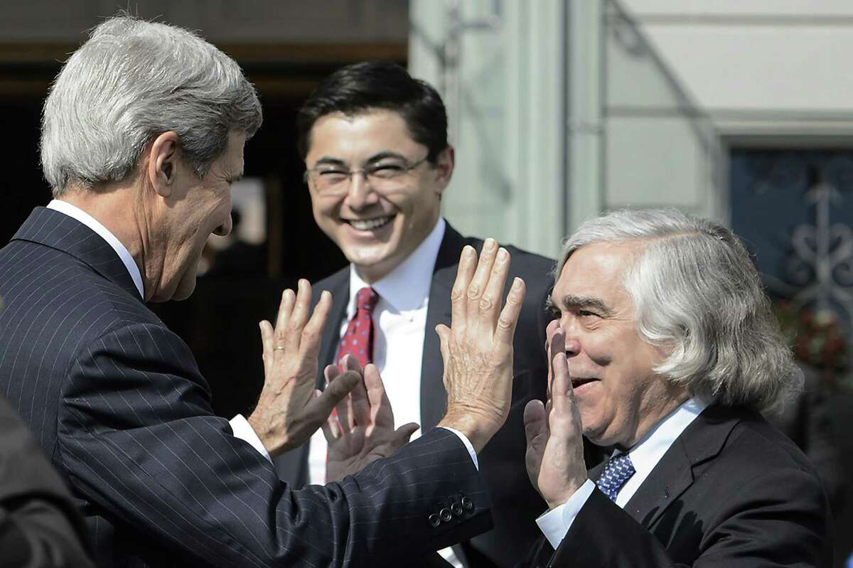 U.S. Secretary of State John Kerry, left, jokes with Ernest Moniz, US Secretary of Energy, right, as they walk outside the hotel during a break from a bilateral meeting with Iranian Foreign Minister Mohammad Javad Zarif for a new round of Nuclear Iran Talks, in Lausanne, Switzerland, Friday, March 27, 2015. (AP Photo/Keystone,Jean-Christophe Bott)