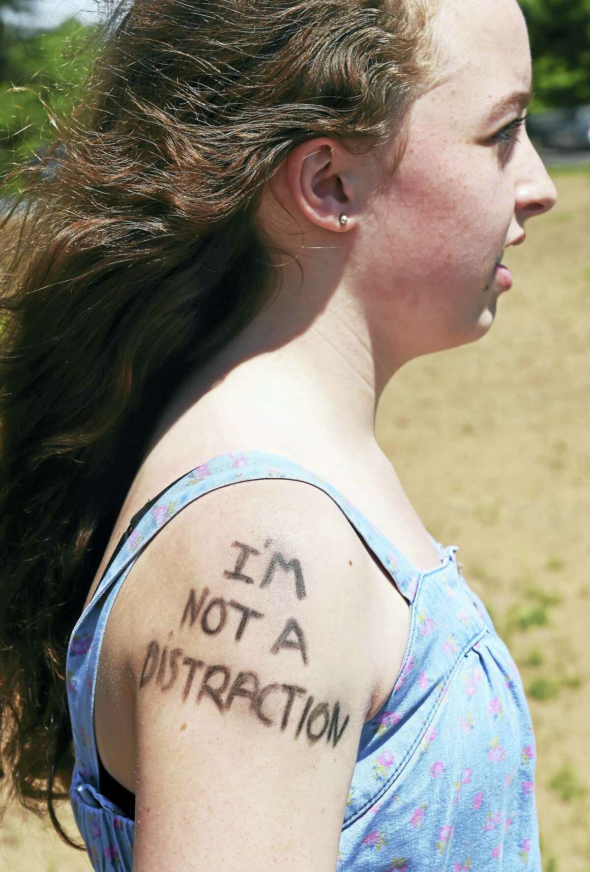 Riley Hawkes was one of a group of students with a message written on her arm Tuesday to protest the dress code and what they said is unfair enforcement at Guilford High School.