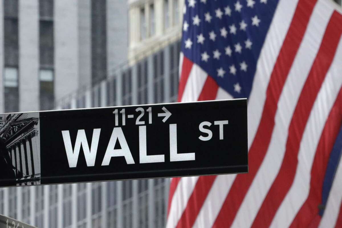 This July 6, 2015 photo shows a Wall Street sign near the New York Stock Exchange. Most major global markets rose Thursday, July 30, 2015, after the U.S. Federal Reserve left interest rates unchanged at a record low, corporate earnings mostly did better than expected and investors awaited U.S. economic growth figures.