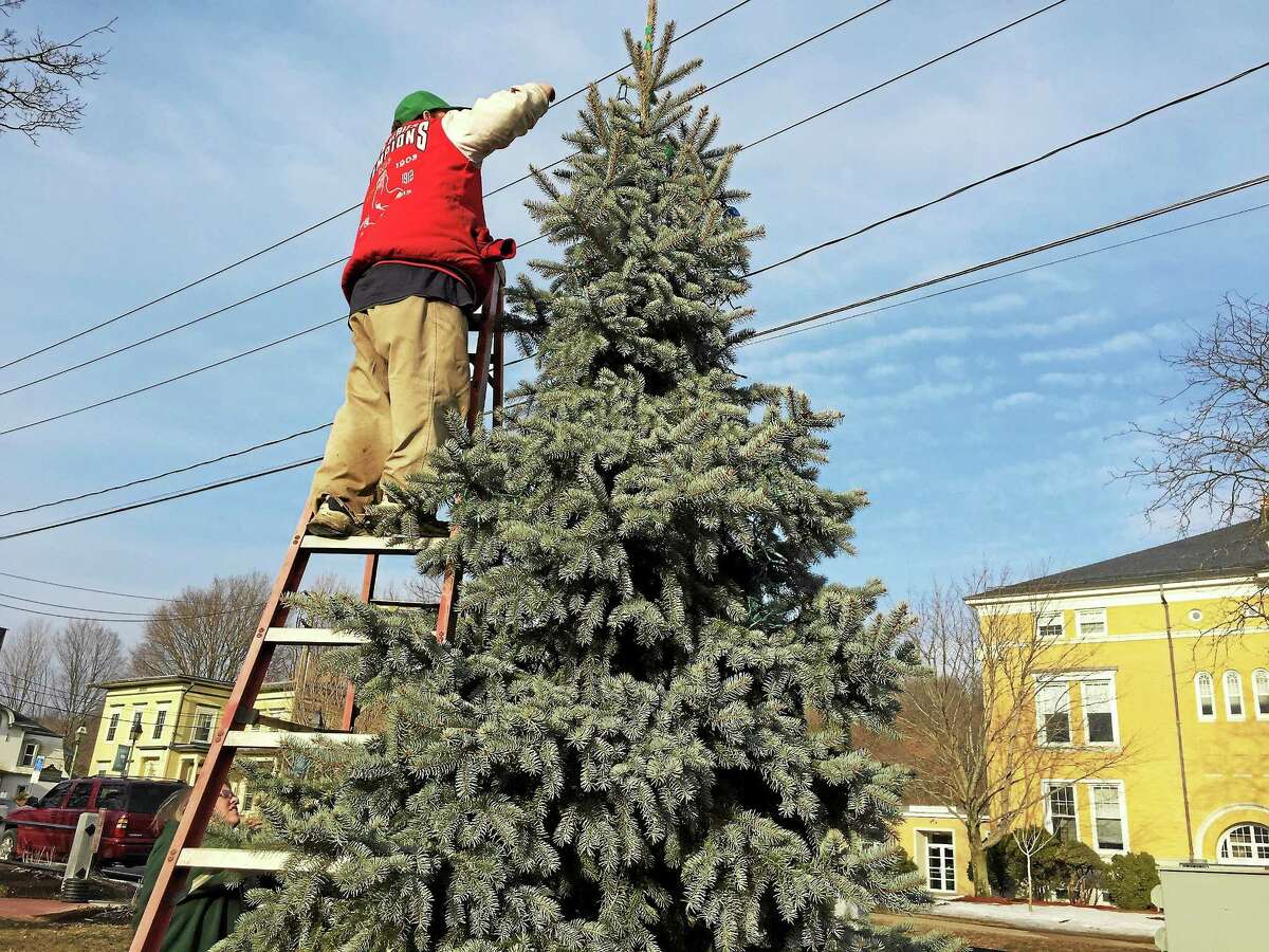 Tim Wheeler helps take down the holiday lights in Winsted on Friday.