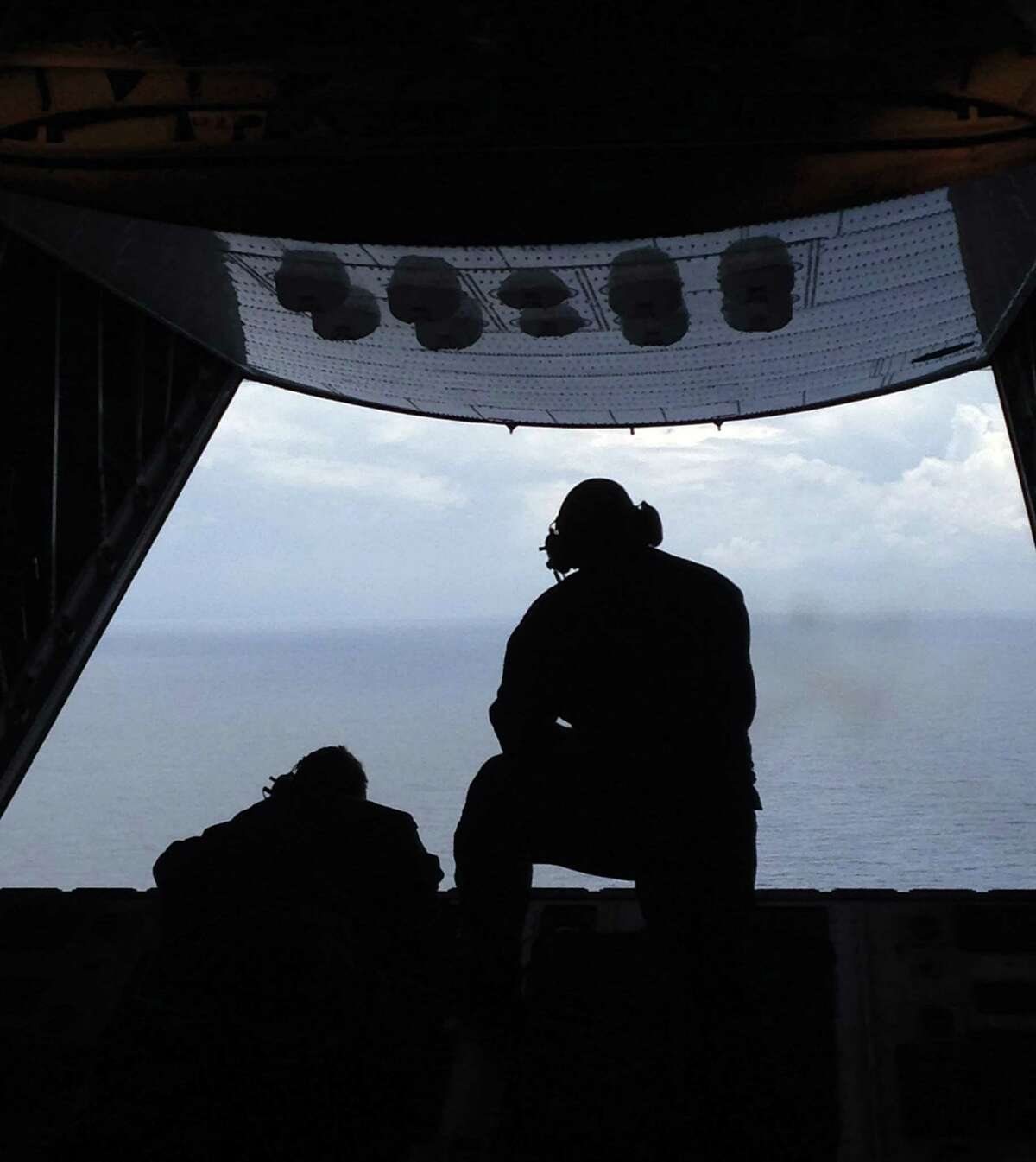 Petty Officer 3rd Class Charles Camarda, left, and Petty Officer 3rd Class Nate Matthews scour the Atlantic Ocean off the coast of Savannah, Ga., Tuesday, looking for two missing teenage boaters. Camarda and Matthews are crew members from Air Station Clearwater, Florida.