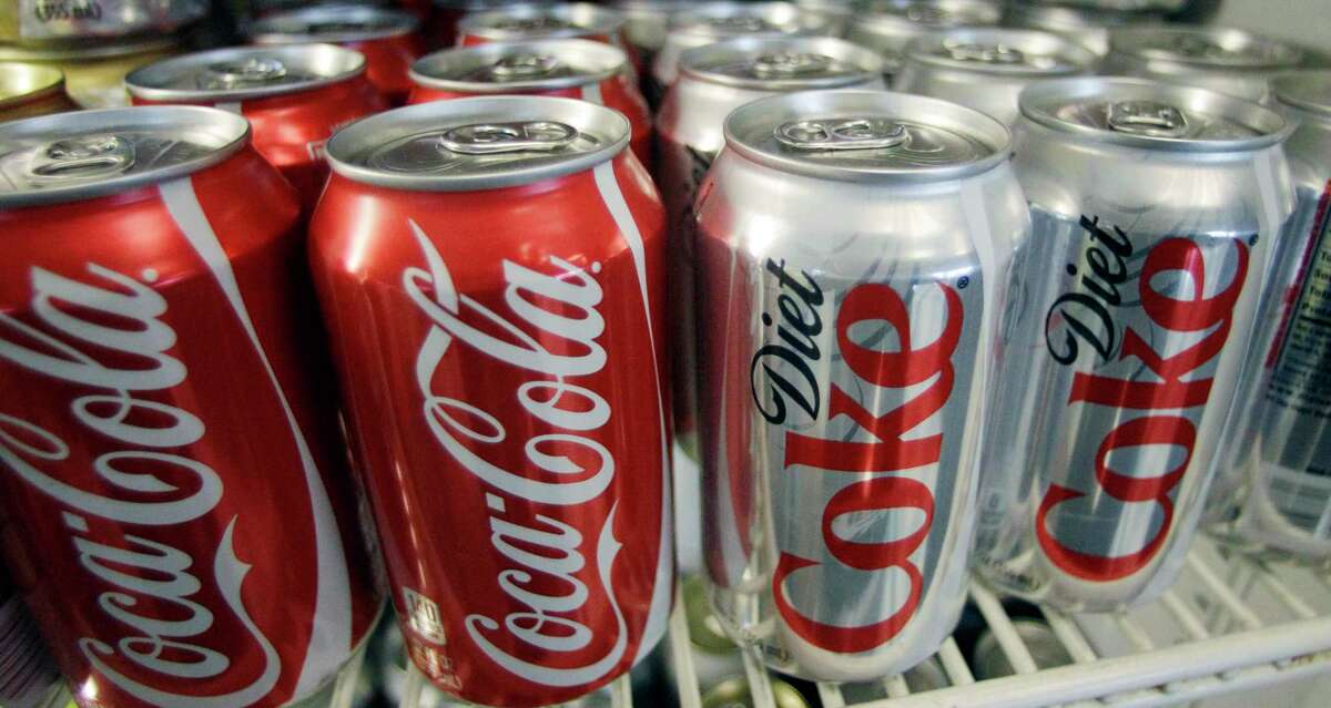 (AP Photo/File) Cans of Coca-Cola and Diet Coke sit in a cooler in Anne’s Deli in Portland, Ore.