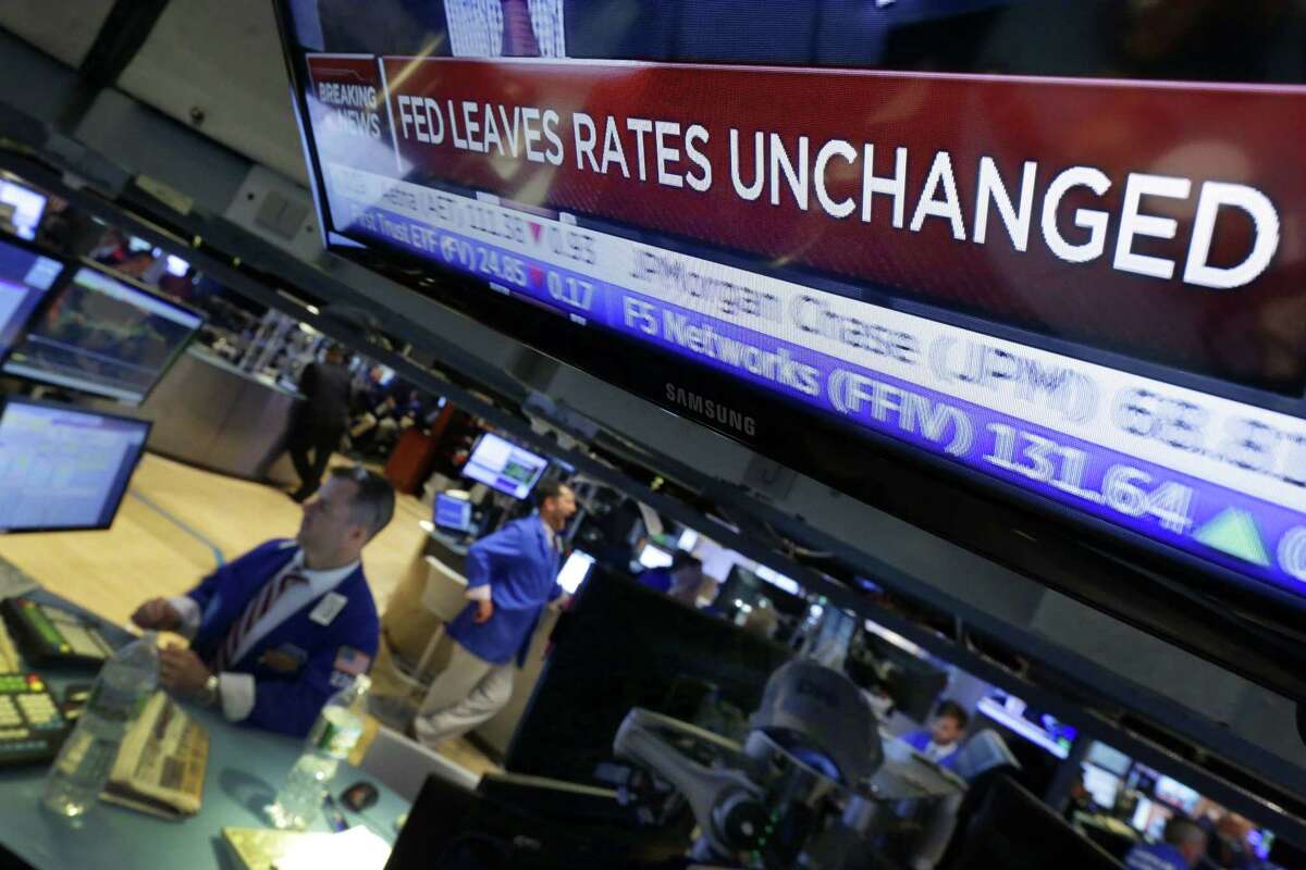 A television screen on the floor of the New York Stock Exchange shows the decision of the Federal Reserve Wednesday.