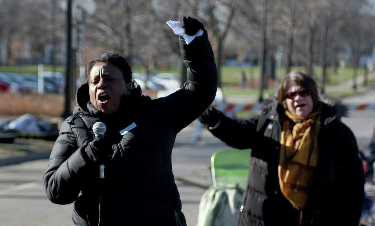 Grace Jones, of the AFSCME union, chants along with the crowd of union workers and protesters before speaking in front of a police precinct Saturday, Nov. 21, 2015, in Minneapolis.