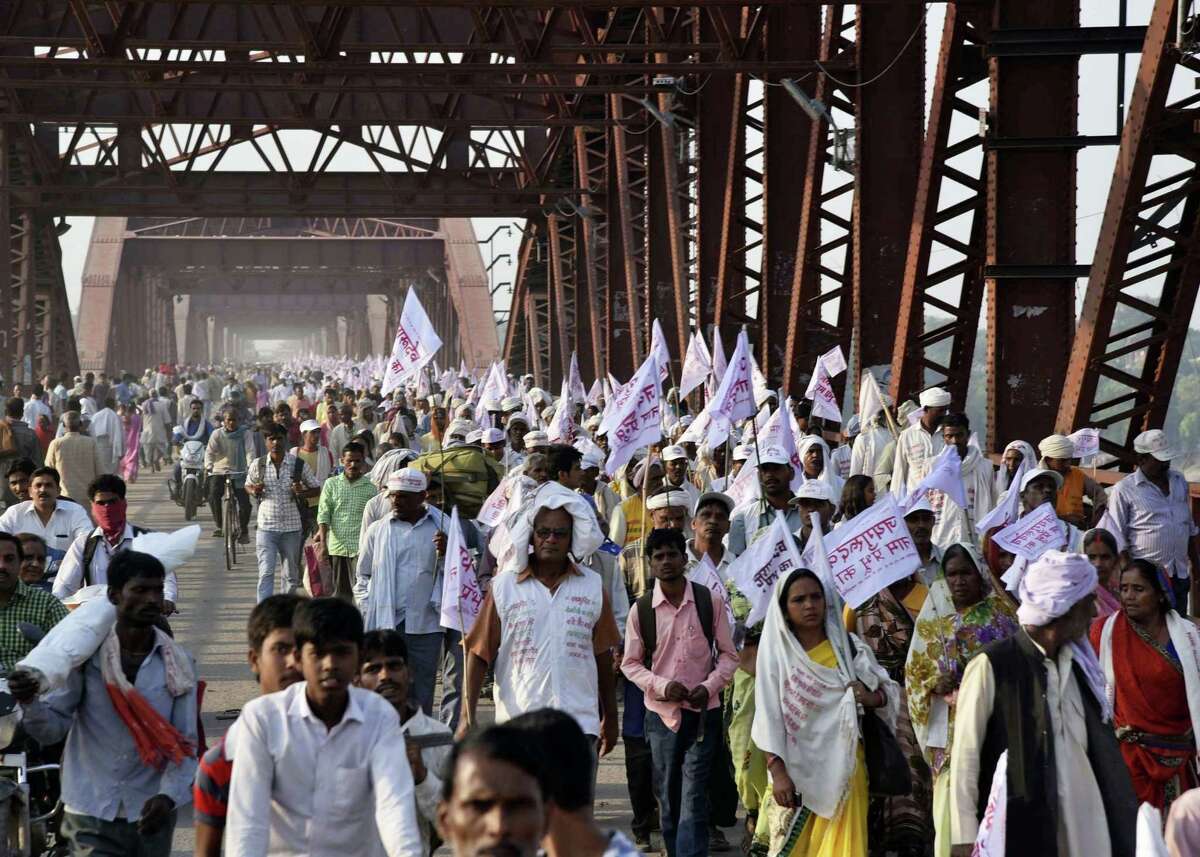 Hindu pilgrims hold religious flags and walk on a crowded bridge after a stampede on the same bridge on the outskirts of Varanasi, India, Saturday, Oct. 15, 2016. More than a dozen people were killed and several more injured in a stampede that occurred as they were crossing a crowded bridge Saturday to reach the venue of a Hindu religious ceremony in northern India, police said. Deadly stampedes are fairly common during Indian religious festivals, where large crowds gather in small areas with few safety or crowd control measures.