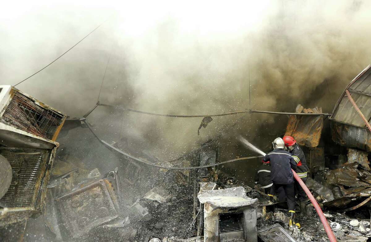 Firefighters work at the scene of a deadly suicide car bomb attack in the New Baghdad neighborhood of Baghdad, Iraq, Thursday, June 9, 2016. Two separate suicide attacks in and outside the Iraqi capital have killed at least 27 people and wounded dozens. Officials say the deadliest bombing took place in New Baghdad, a commercial area of a majority Shiite neighborhood in Baghdad, killing over a dozen civilians. Another suicide bomber rammed his explosives-laden car into an Iraqi army checkpoint north of Baghdad, killing at least 12 people.