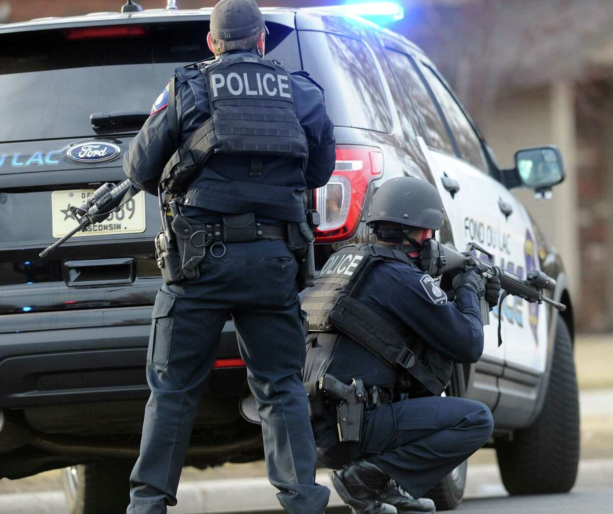 In this Tuesday, March 24, 2015 photo, officers work the scene where a Wisconsin State Patrol trooper just three months out of the academy died in a shootout with a bank robbery suspect also believed to have killed another motorist, in Fond du Lac, Wis. The suspect also died in the shootout. (AP Photo/The Reporter, Doug Raflik)