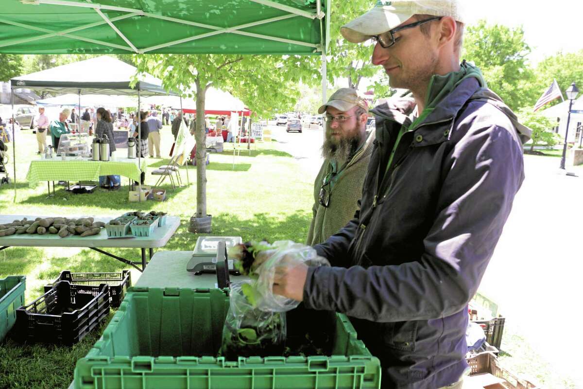 At the New Milford Farmers Market earlier this year are Elliott McGann, in foreground, and Alpen Martel of Fort Hill Farm, which is located at 18 Fort Hill Road, New Milford. The farm is included in this weekend’s farm crawl, giving the public the chance to learn more about those who produce their food.