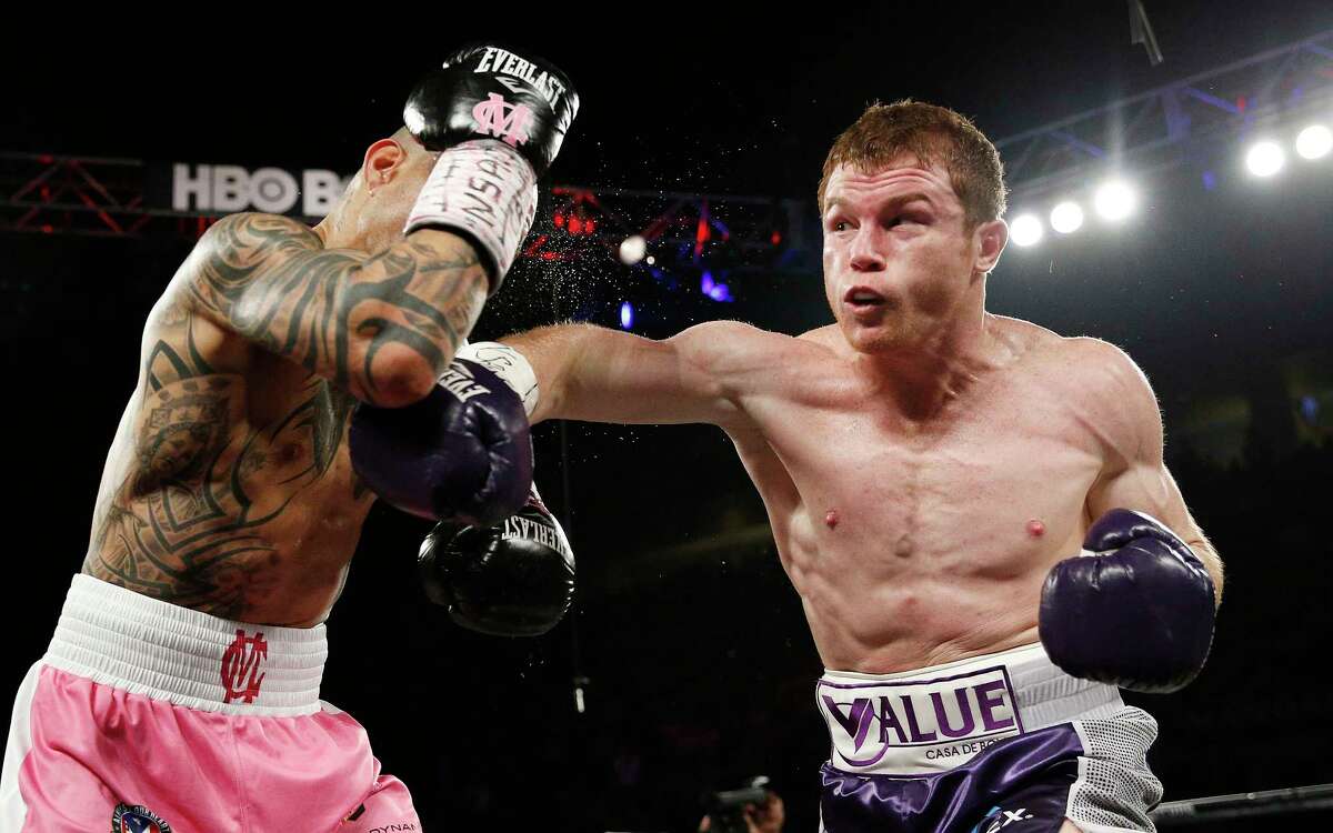 Canelo Alvarez hits Miguel Cotto during their WBC middleweight title bout on Saturday. Alvarez won by unanimous decision.