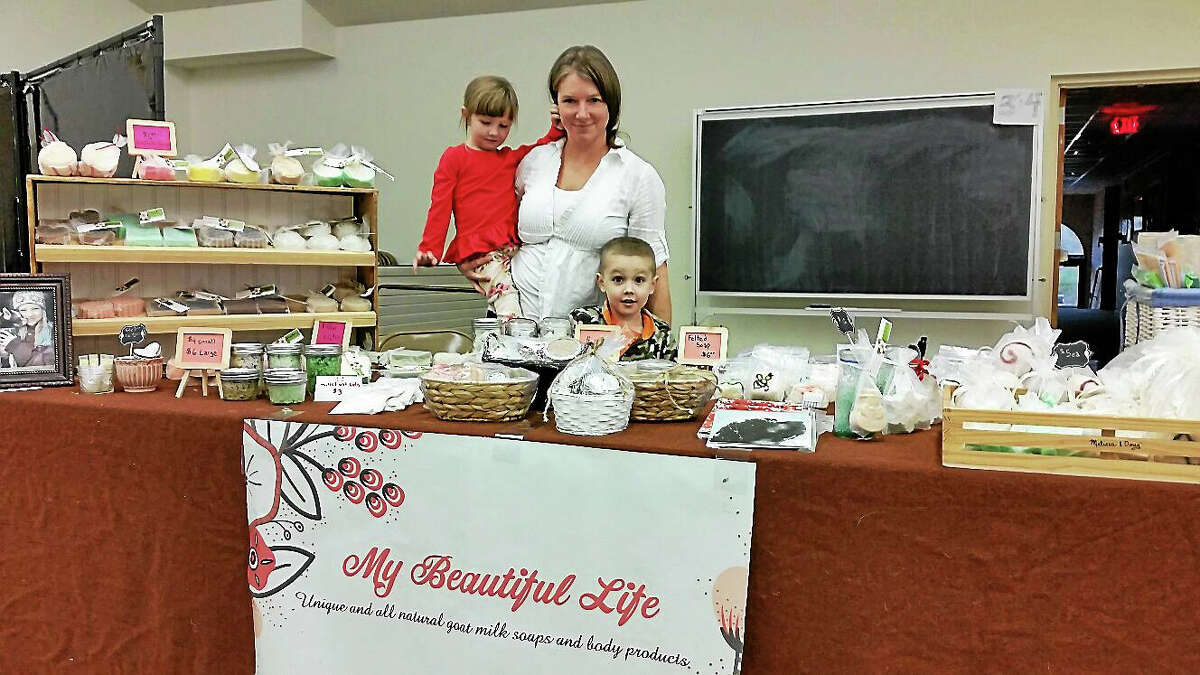 N.F. Ambery Organizer Tina Torizzo of Goshen pauses with her children Amelia, 3, and AJ, 5, at her table for her goat-milk-soap company My Beautiful Life.