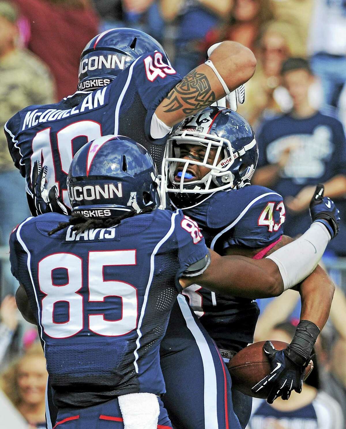 Sean McQuillan (49) celebrates with Lyle McCombs (43) and Geremy Davis (85) after a McCombs touchdown in a 2013 game.